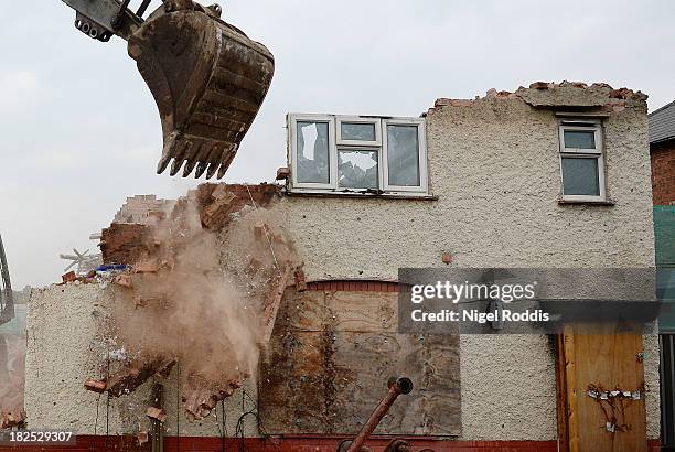 Builders begin to demolish the semi-detached house at 18 Victory Road where six children died in a fire started by their parents Mick and Mairead...