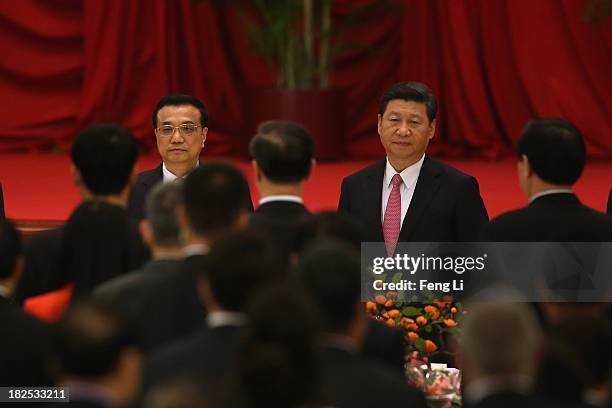 Chinese President Xi Jinping and Premier Li Keqiang attend a reception marking the 64th anniversary of the founding of the People's Republic of China...