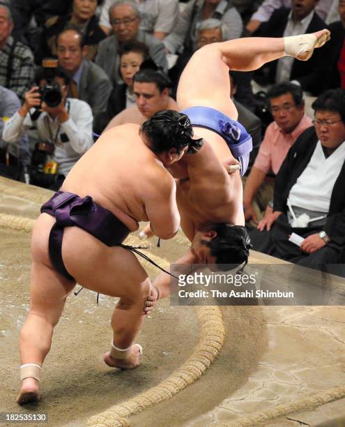Takekaze throws Okinoumi to win during day fifteen of the Grand Sumo Autumn Tournament at Ryogoku Kokugikan on September 28, 2013 in Tokyo, Japan.