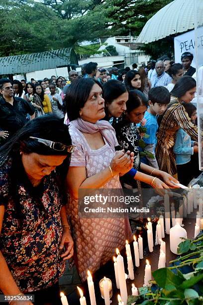 People gather for prayers and tributes for the Westgate Terror attack victims on September 27, 2013 outside Westgate Maill in Nairobi, Kenya. The...