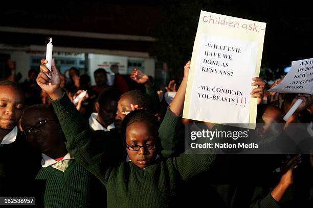 Pupil from Moi Nyeri Complex lifts up her hands during prayers and tributes for the Westgate Terror attack victims on September 27, 2013 outside...