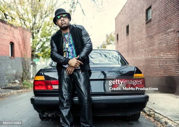 man in old school hip hop clothing standing in front of classic car - music from the motor city stock pictures, royalty-free photos & images