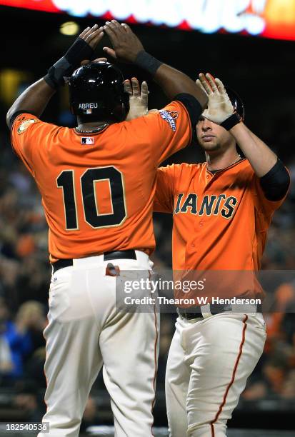 Brandon Belt of the San Francisco Giants is congratulated by Tony Abreu after hitting a two-run homer during the third inning against the San Diego...