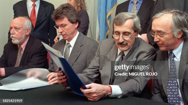 Jose Botafogo, Ricardo Wirth, Carlos Bueno and Jorge Campbell exchange documents at a meeting in Montevideo, Uruguay, 29 September 1999. Jose...