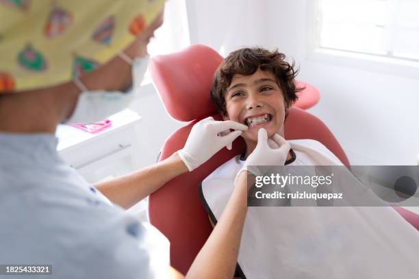 dentist woman and teenager boy patient during dental consultation - aparelho dentário imagens e fotografias de stock