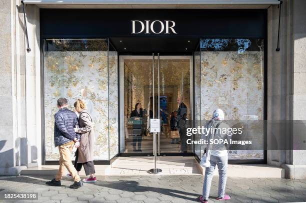 Shoppers walk past the Christian Dior luxury goods, clothing, and beauty products store seen in Spain.