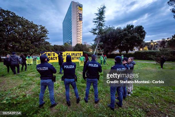 The police check the Greenpeace activists placed an 8-metre long installation near the ENI headquarters building with the message 'ENI's legacy =...