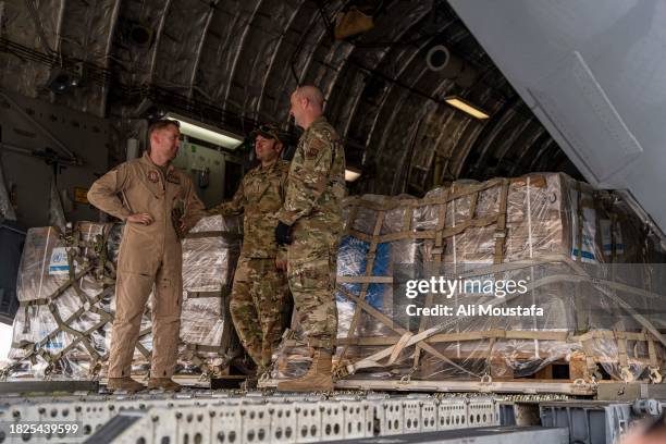 United States Airforce personnel stand on a Boeing C-17 Globemaster III as it prepares to deliver aid intended for the Gaza Strip is delivered at El...