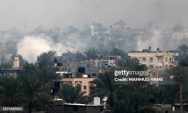 Smoke rises above buildings in Khan Yunis in the southern Gaza Strip, as battles between Israel and Hamas militants continue on December 5, 2023....