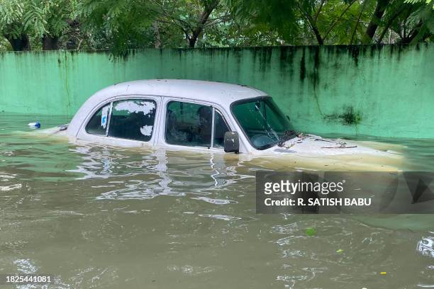 Car is seen partially submerged in a flooded street in Chennai on December 5 following intense rains after Cyclone Michaung made a landfall....