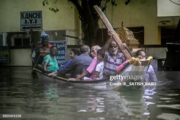 Volunteers steer a boat as they evacuate residents from a flooded area in Chennai on December 5 following intense rains after Cyclone Michaung made a...