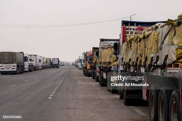 Trucks with aid destined for the Gaza Strip are parked on the side of the road on December 5, 2023 in Arish, Egypt.