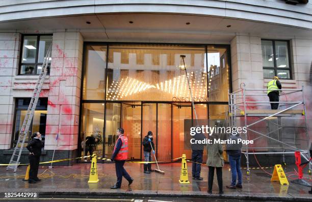 Specialist cleaning team get to work on the paint covered exterior of the building on December 5, 2023 in London, United Kingdom. Protest group...
