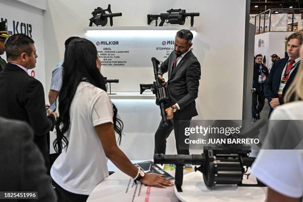 Man shows grenade launcher during the Expodefense in Bogota, on December 5, 2023.