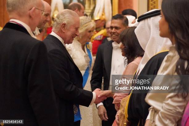 Britain's King Charles III meets with guests during a reception for members of the Diplomatic Corps at Buckingham Palace, in London, on December 5,...
