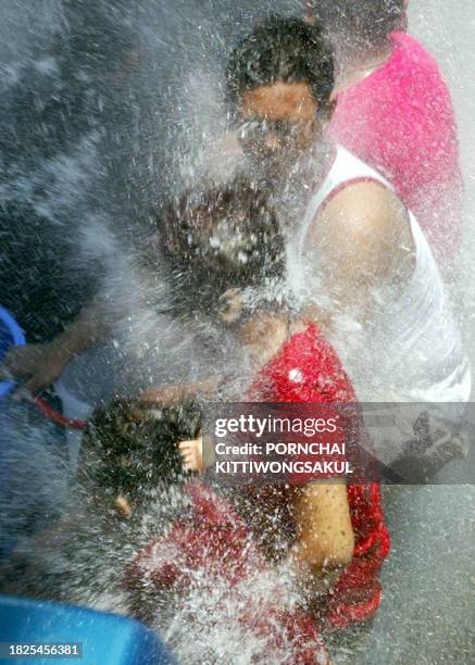 Thai teenagers enjoy a water battle on the back of a truck during celebration of Songkran fesitival in Bangkok, 15 April 2003. Thai Public Health...