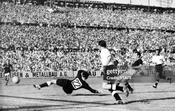 Hungarian forward Nandor Hidegkuti scores the fifth goal for his team past German goalkeeper Heiner Kwiatkowski as Werner Kohlmeyer looks on during...