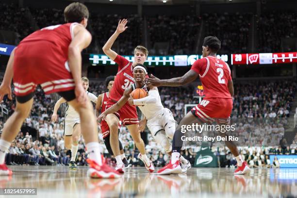 Tyson Walker of the Michigan State Spartans drives past Ross Candelino and AJ Storr of the Wisconsin Badgers during the first half at Breslin Center...