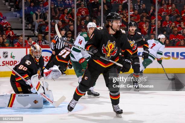 Rasmus Andersson of the Calgary Flames battles against the Minnesota Wild at Scotiabank Saddledome on December 5, 2023 in Calgary, Alberta, Canada.