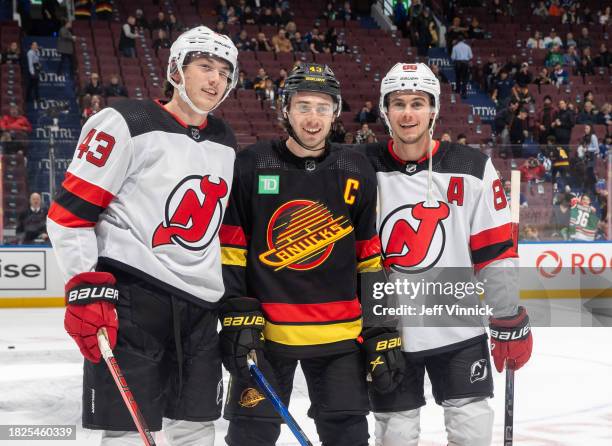 Quinn Hughes of the Vancouver Canucks and Jack Hughes and Luke Hughes of the New Jersey Devils pose for a photo before their NHL game at Rogers Arena...