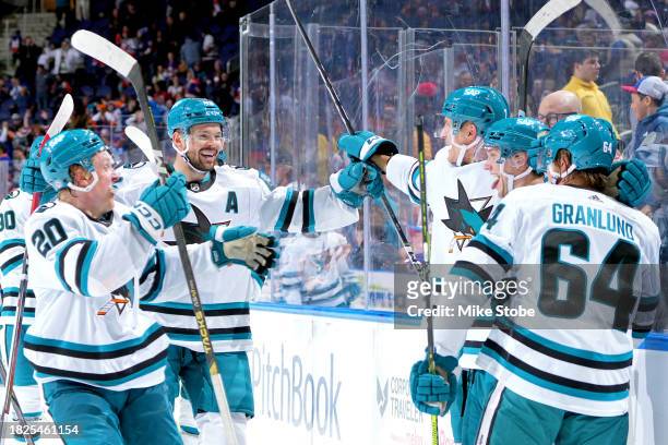 William Eklund of the San Jose Sharks is congratulated by his teammates after scoring the game-winning goal against the New York Islanders during...