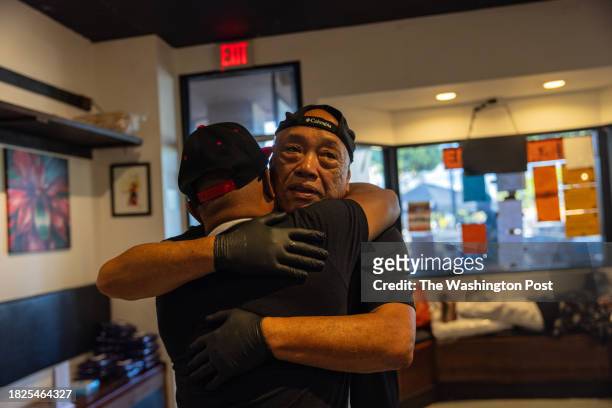 Joey Macadangdang, chef and owner of Joey's Kitchen, hugs his friend Gene Wong, who has been volunteering at the restaurant, as they prepare to...