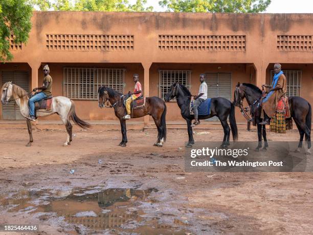 Madi Derme poses with his apprentices on horses in Ouagadougou, Burkina Faso, on July 18, 2023....