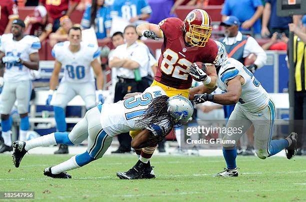 Logan Paulsen of the Washington Redskins is tackled by Rashean Mathis and DeAndre Levy of the Detroit Lions at FedExField on September 22, 2013 in...