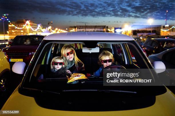 Visitors look with special 3D glasses from their car to the latest Disney movie Planes, during the drive-in movie theater on the parking of Amsterdam...