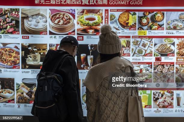 Customers look at a restaurant menu in a shopping street in Taipei, Taiwan, on Wednesday, Dec. 6, 2023. Taiwan's consumer prices rose more than...