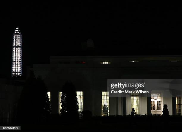 People stand in front of the West Wing of the White House on the eve of a possible government shut down, September 30, 2013 in Washington, DC. If...