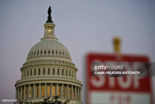Stop sign is seen at dusk next to the US Congress building on the eve of a possible government shutdown as Congress battles out the budget in...