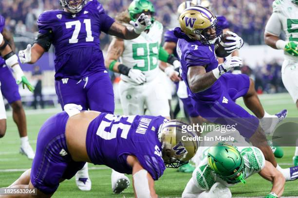 Dillon Johnson of the Washington Huskies runs over Evan Williams of the Oregon Ducks while scoring a rushing touchdown during the first quarter...