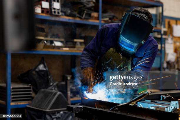 welder working at a factory using a protective face mask - industrial laborer stock pictures, royalty-free photos & images