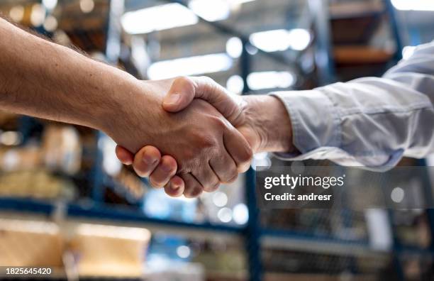 gerente de almacén contratando a un empleado y dándole la mano - típico de la clase trabajadora fotografías e imágenes de stock