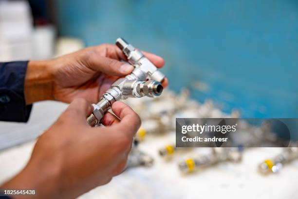 close-up on a worker making pipeline valves at a factory - machine valve stock pictures, royalty-free photos & images