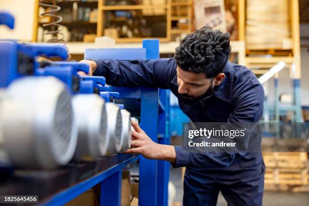 employee working at a manufacturing factory assembling water pumps - bomba de água equipamento imagens e fotografias de stock