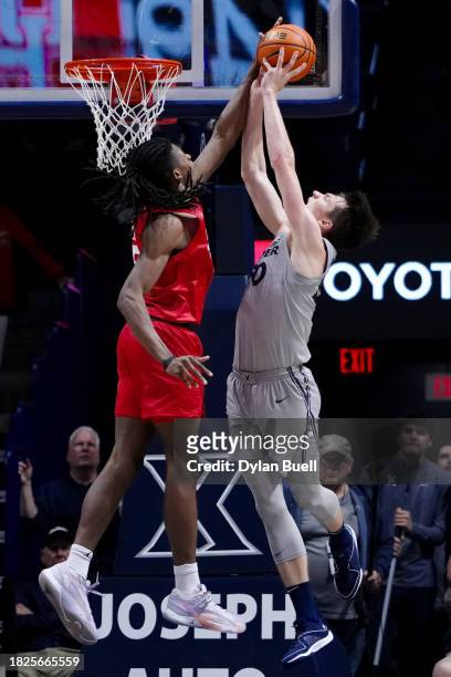 Joseph Tugler of the Houston Cougars blocks a shot attempt by Gytis Nemeikša of the Xavier Musketeers in the second half at the Cintas Center on...
