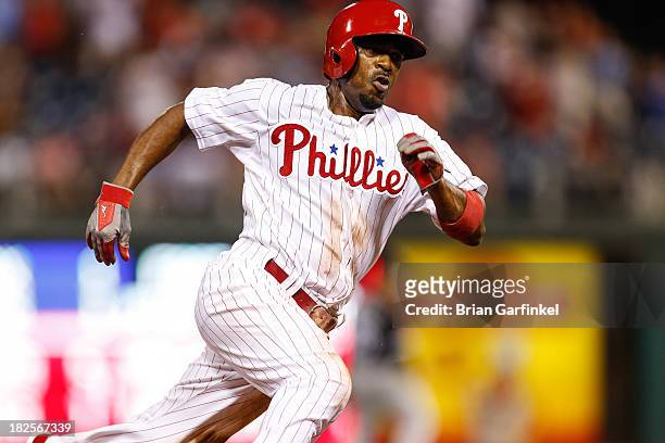 Jimmy Rollins of the Philadelphia Phillies rounds third base to score a run in the thirteenth inning of the second game of a double header against...