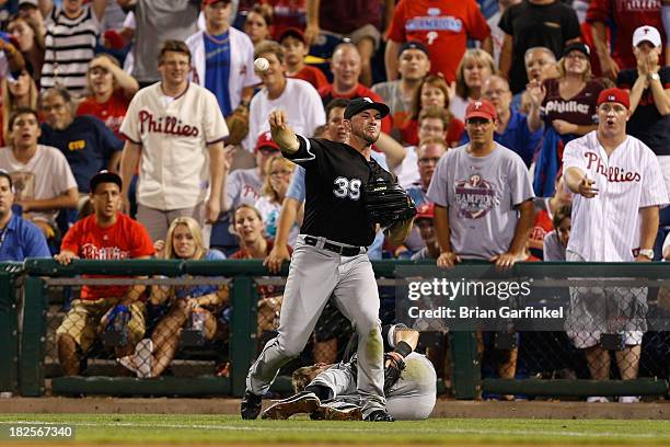 Casper Wells of the Chicago White Sox throws the ball infield as Gordon Beckham lays on the ground after a collision during the second game of a...