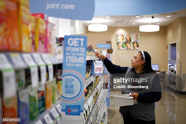 Walgreen Co. Assistant Store Manager Tammy Jenkins updates price tags at one of the company's stores in Louisville, Kentucky, U.S., on Monday, Sept....