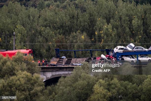 Derailed freight train, transporting Fiat cars, is pictured in Voeren on October 1, 2013. Three wagons fell off a bridge. Nobody got injured. AFP...