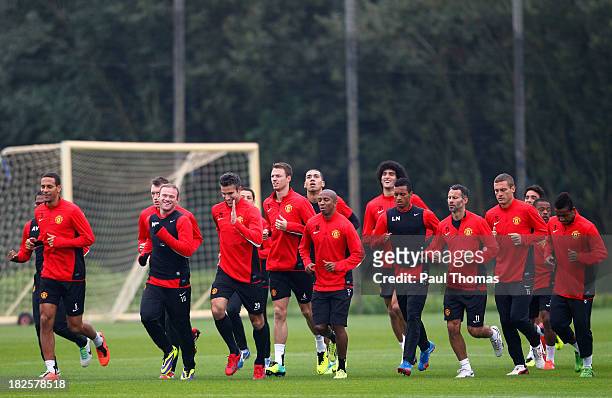 Manchester United players warm up during a training session ahead of their Champions League Group A match against Shakhtar Donetsk at their...