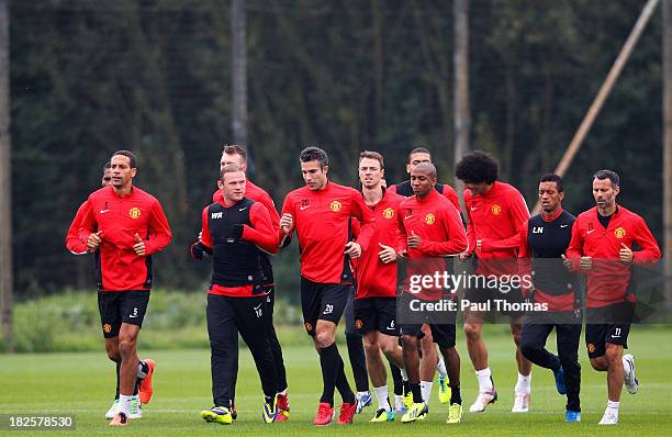 Manchester United players warm up during a training session ahead of their Champions League Group A match against Shakhtar Donetsk at their...