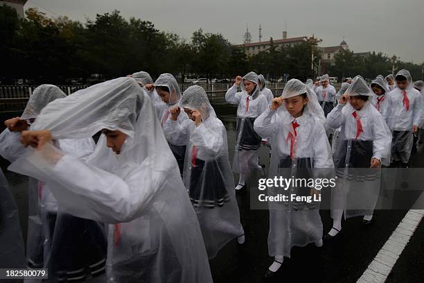 Chinese students walk to Tiananmen Square before a ceremony marking the 64th anniversary of the founding of the People's Republic of China at...