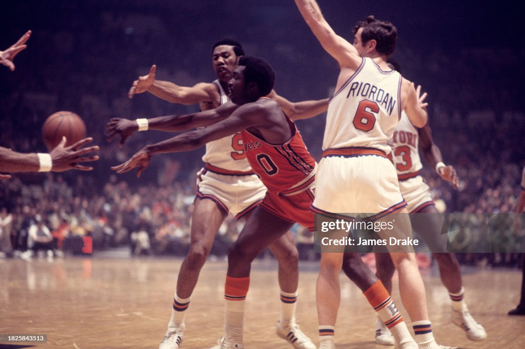 Earl Monroe of the Baltimore Bullets passes against Mike Riordan and