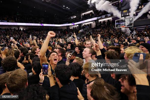 Ty Berry of the Northwestern Wildcats celebrate with fans after defeating the Purdue Boilermakers 92-88 in overtime at Welsh-Ryan Arena on December...