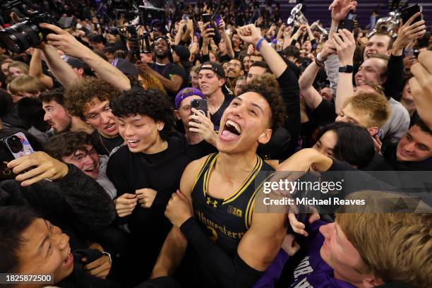 Ty Berry of the Northwestern Wildcats celebrate with fans after defeating the Purdue Boilermakers 92-88 in overtime at Welsh-Ryan Arena on December...