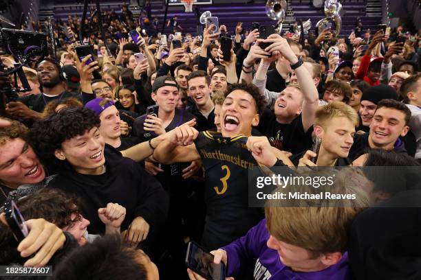 Ty Berry of the Northwestern Wildcats celebrate with fans after defeating the Purdue Boilermakers 92-88 in overtime at Welsh-Ryan Arena on December...