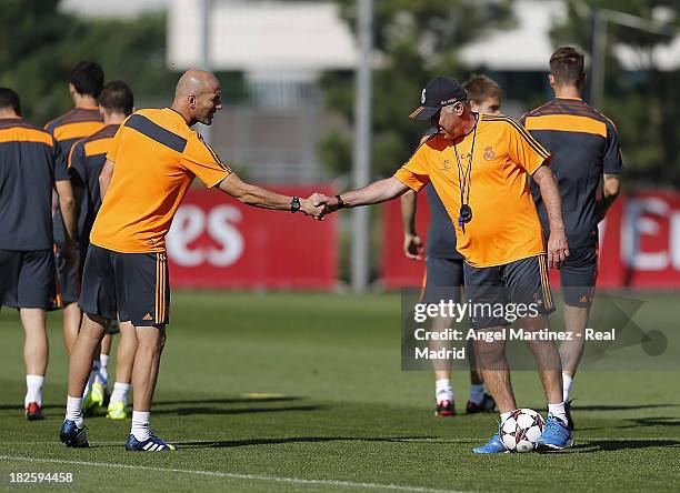 Head coach Carlo Ancelotti and his assistant Zinedine Zidane of Real Madrid shake hands during a training session ahead of their UEFA Champions...